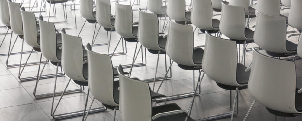 Leere Stuhlreihen im Konferenzraum