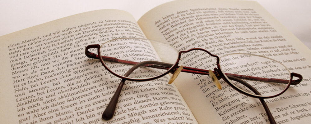 Brille liegt auf einem geöffnetem Buch