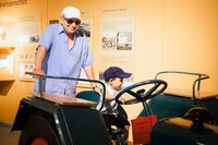 Alter und junger Mann auf einem Traktor im Museum