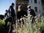 Gacruppe von Menschen schaut Haus von außen an