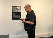 Person steht vor einem Bild in einer Ausstellung