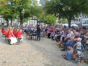 Foto: Menschen haben sich auf einem Platz versammelt um gemeinsam zu singen
