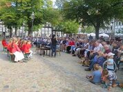Foto: Menschen haben sich auf einem Platz versammelt um gemeinsam zu singen