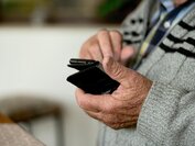 Ältere Person mit Handy in der Hand