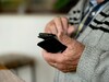 Ältere Person mit Handy in der Hand