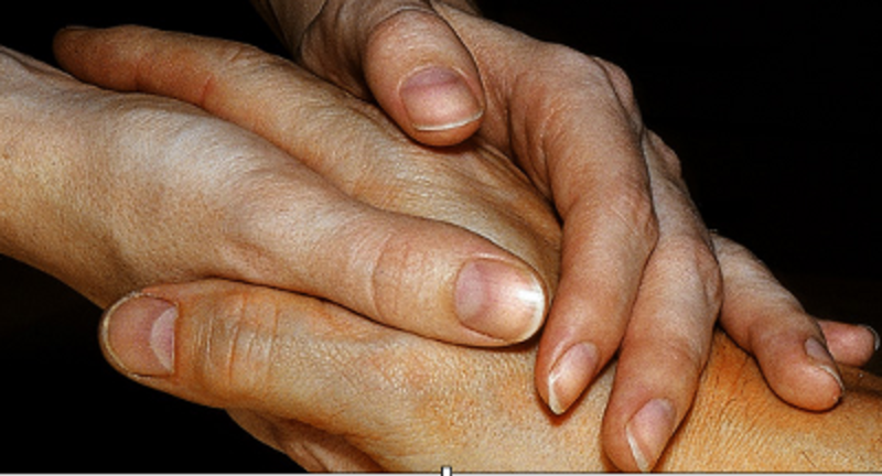 Hand umschließt schützend eine andere Hand